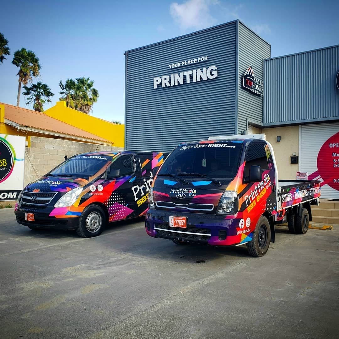 Print Media Aruba wrapped vans in front of the shop