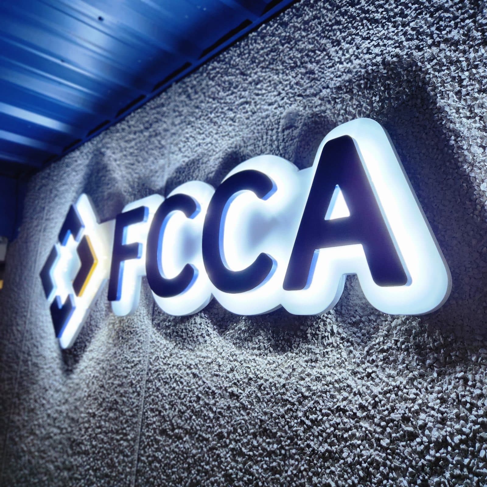 Illuminated FCCA channel letters on a textured wall
